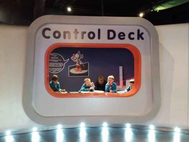 Four beaver scouts are playing in a room named Control Deck.