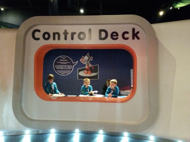 Three beaver scouts are playing in a room named Control Deck.